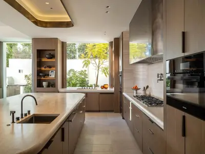 a kitchen with wooden cabinets and a large window at Stradella Mansion in Los Angeles