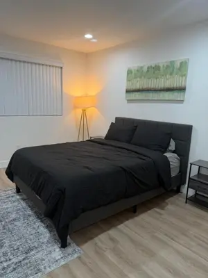 a bedroom with a bed with a black comforter at Comfortable & Quaint Room in a Shared Space in Van Nuys