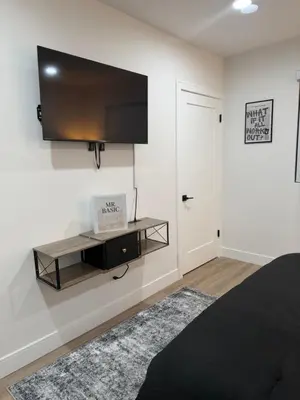 a bedroom with a flat screen tv on the wall at Comfortable & Quaint Room in a Shared Space in Van Nuys