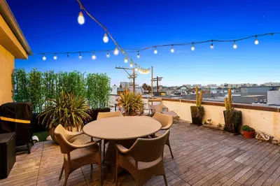 a patio with a table and chairs on a balcony at Northstar Premium Ocean Penthouse in Los Angeles