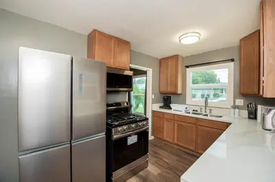 a kitchen with stainless steel appliances and wooden cabinets at Welcome to your home at the Orange Circle in Orange
