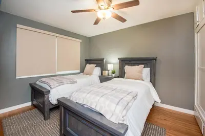 two beds in a bedroom with a ceiling fan at Welcome to your home at the Orange Circle in Orange