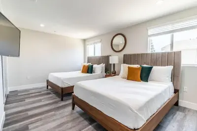 a bedroom with two beds and a mirror on the wall at Escape in Modern 4BR Home Sleeps 10 with Parking in Burbank