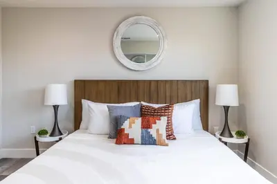 a bedroom with a large white bed with a mirror at Escape in Modern 4BR Home Sleeps 10 with Parking in Burbank