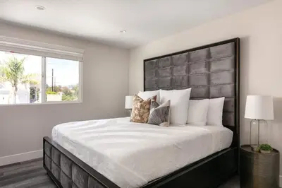 a bedroom with a large bed with a large headboard at Spacious Home Central Area Airport Free Parking in Burbank