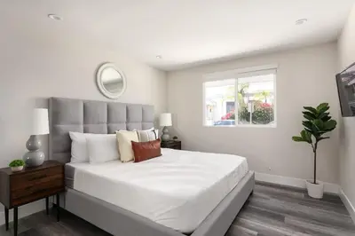 a bedroom with a large white bed with a window at Spacious Home Central Area Airport Free Parking in Burbank