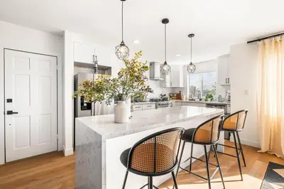 a kitchen with a large white island with chairs at Charming LA Gem by SOFI, Games & Close to it ALL in Los Angeles