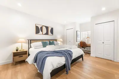 a white bedroom with a large bed and a desk at Charming LA Gem by SOFI, Games & Close to it ALL in Los Angeles