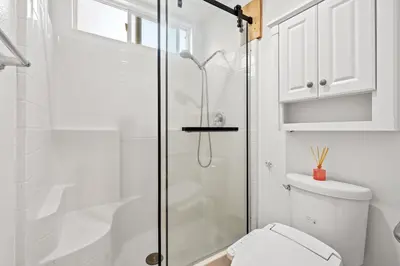 a white bathroom with a shower and a toilet at Luxury Hilltop Home Spacious Private Backyard in Rowland Heights