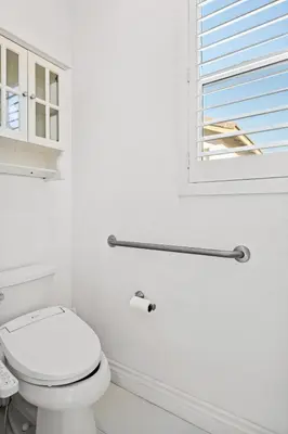 a white bathroom with a toilet and a window at Luxury Hilltop Home Spacious Private Backyard in Rowland Heights
