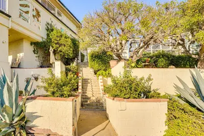 a house with two large pots of plants in front of it at Beachfront Living in Long Beach 2,500 Sq Ft Condo in Long Beach