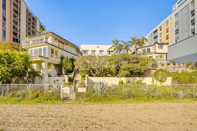 a house in the middle of some buildings at Beachfront Living in Long Beach 2,500 Sq Ft Condo in Long Beach