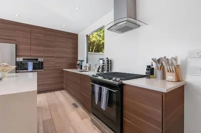 a kitchen with wooden cabinets and a stove top oven at New Listing Sunset Retreat by Colby&Conrad in Los Angeles