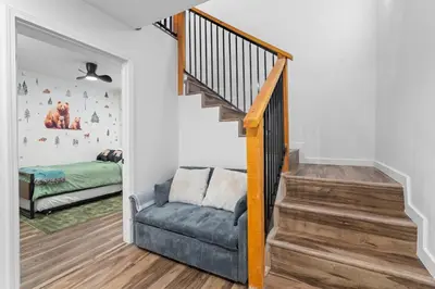 a living room with a staircase and a couch at Tall Pines Retreat Large Patio w BBQ and Firepit! in Big Bear City Airport