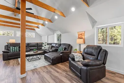 a living room with leather furniture and wooden ceilings at Tall Pines Retreat Large Patio w BBQ and Firepit! in Big Bear City Airport
