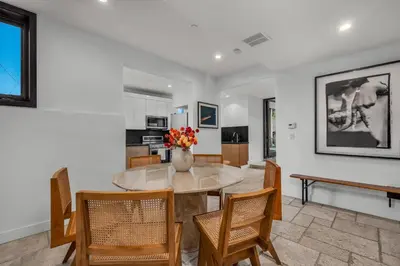 a dining room with a table and chairs and a vase of flowers at Ridpath Retreat Guest House in Los Angeles