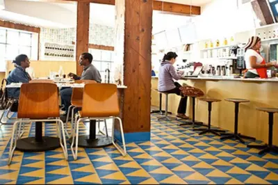 a restaurant with people sitting at a bar at Secret Stairs Family in Los Angeles