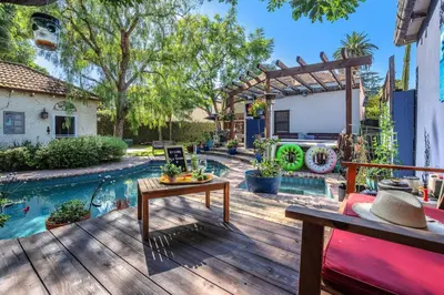 a backyard with a pool and a wooden deck at Villa Victoria Guest House in Los Angeles