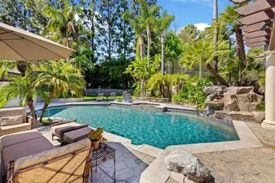 a swimming pool in a backyard with palm trees at Marbella Lane - Tranquil Country Escape Getaway in Placentia