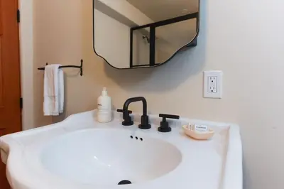 a white bathroom sink with a mirror and a soap dispenser at Lush Venice Beach Oasis Home -just steps to beach in Los Angeles