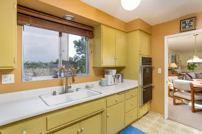 a kitchen with yellow cabinets and a sink and a window at NEW Vintage Canyon Retreat in Mount Washington in Los Angeles