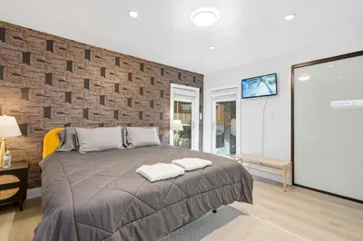 a bedroom with a bed and a brick wall at Bel Air Very Private and Comfy Home with Jacuzzi in Los Angeles