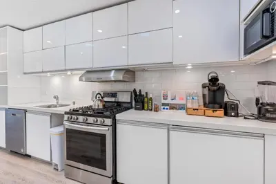a kitchen with white cabinets and a stove at Bel Air Very Private and Comfy Home with Jacuzzi in Los Angeles