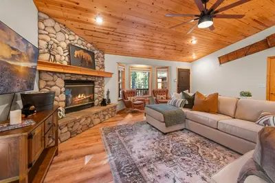 a living room with a couch and a fireplace at Pine Cottage - NEW! Shuffleboard, Pool Table, Smart TVs, Fenced Yard in Big Bear Lake
