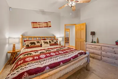 a bedroom with a large bed and a dresser at Pine Cottage - NEW! Shuffleboard, Pool Table, Smart TVs, Fenced Yard in Big Bear Lake