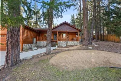 a log home with a golf course in the woods at Pine Cottage - NEW! Shuffleboard, Pool Table, Smart TVs, Fenced Yard in Big Bear Lake