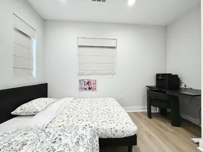 a white bedroom with a bed and a desk at Marbella Lane Spacious 4BR Modern Family Home in Placentia