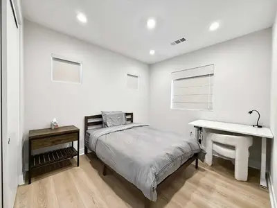 a bedroom with a bed and a desk and a table at Marbella Lane Spacious 4BR Modern Family Home in Placentia