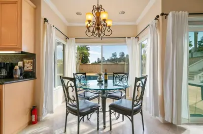 a dining room with a glass table and chairs at Marbella Lane - Captivating Home w Pool in Rowland Heights