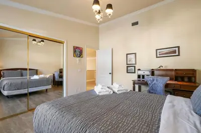 a bedroom with a bed with a mirror and a desk at Marbella Lane - Captivating Home w Pool in Rowland Heights