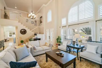 a living room with white furniture and a staircase at Marbella Lane - Revitalizing Getaway w Pool in Rowland Heights
