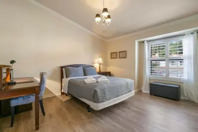 a bedroom with a bed and a desk and a window at Marbella Lane - Revitalizing Getaway w Pool in Rowland Heights