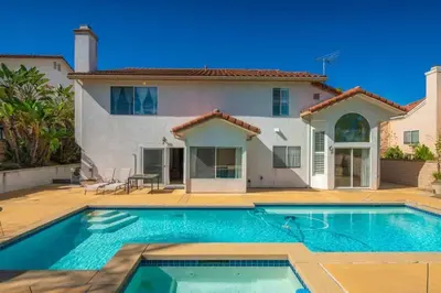 a villa with a swimming pool in front of a house at Marbella Lane - Revitalizing Getaway w Pool in Rowland Heights