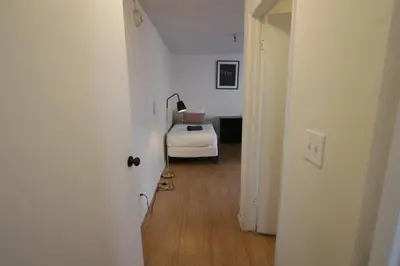 a hallway with a bed in a white room at 3 beds Apart in Beverly Hills Neighborhood in Los Angeles