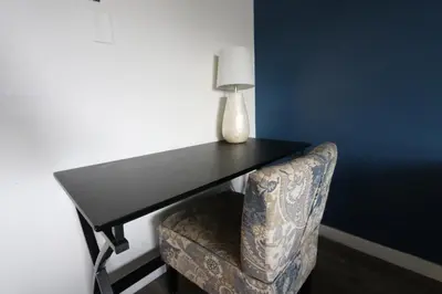 a table and a chair with a vase on top at Nice Queed bed apt in Beverly Hills neighborhood in Los Angeles