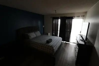 a dark bedroom with a bed and a window at Nice Queed bed apt in Beverly Hills neighborhood in Los Angeles