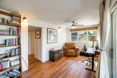 a living room with a desk and a chair at Spacious Riverside Farmhouse, Perfectly Located in Riverside