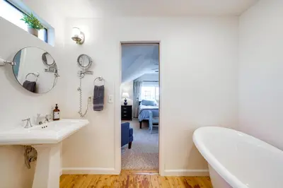 a bathroom with a sink and a mirror and a tub at Spacious Riverside Farmhouse, Perfectly Located in Riverside