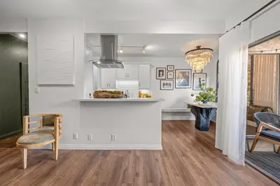 a kitchen with white cabinets and a table and chairs at Luca's Tree Flat - Los Angeles California in Studio City