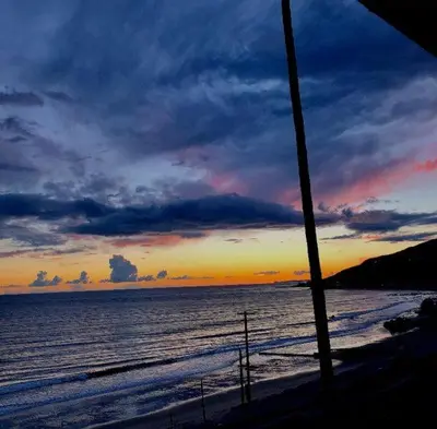 a sunset on a beach with the ocean at Villa Porto Marina - Oceanfront Living in Castellammare