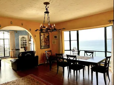 a dining room with a table and chairs and the ocean at Villa Porto Marina - Oceanfront Living in Castellammare