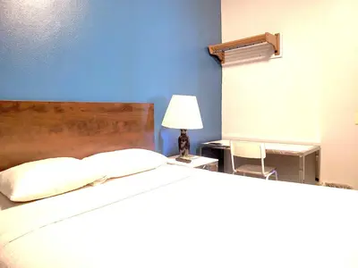 a bedroom with a large bed with a blue wall at AVAION HOTEL LAX SoFi STADIUM in Inglewood