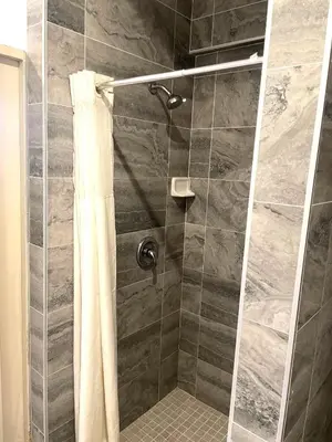 a bathroom with a shower with a shower curtain at AVAION HOTEL LAX SoFi STADIUM in Inglewood