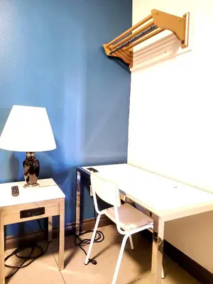 a desk and a chair next to a desk with a lamp at AVAION HOTEL LAX SoFi STADIUM in Inglewood