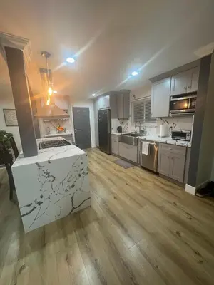 a large kitchen with wooden floors and stainless steel appliances at Minimalist Room in Buena Park in Buena Park