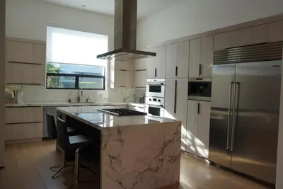 a kitchen with a marble counter top and stainless steel refrigerator at The Hollywood House in Los Angeles